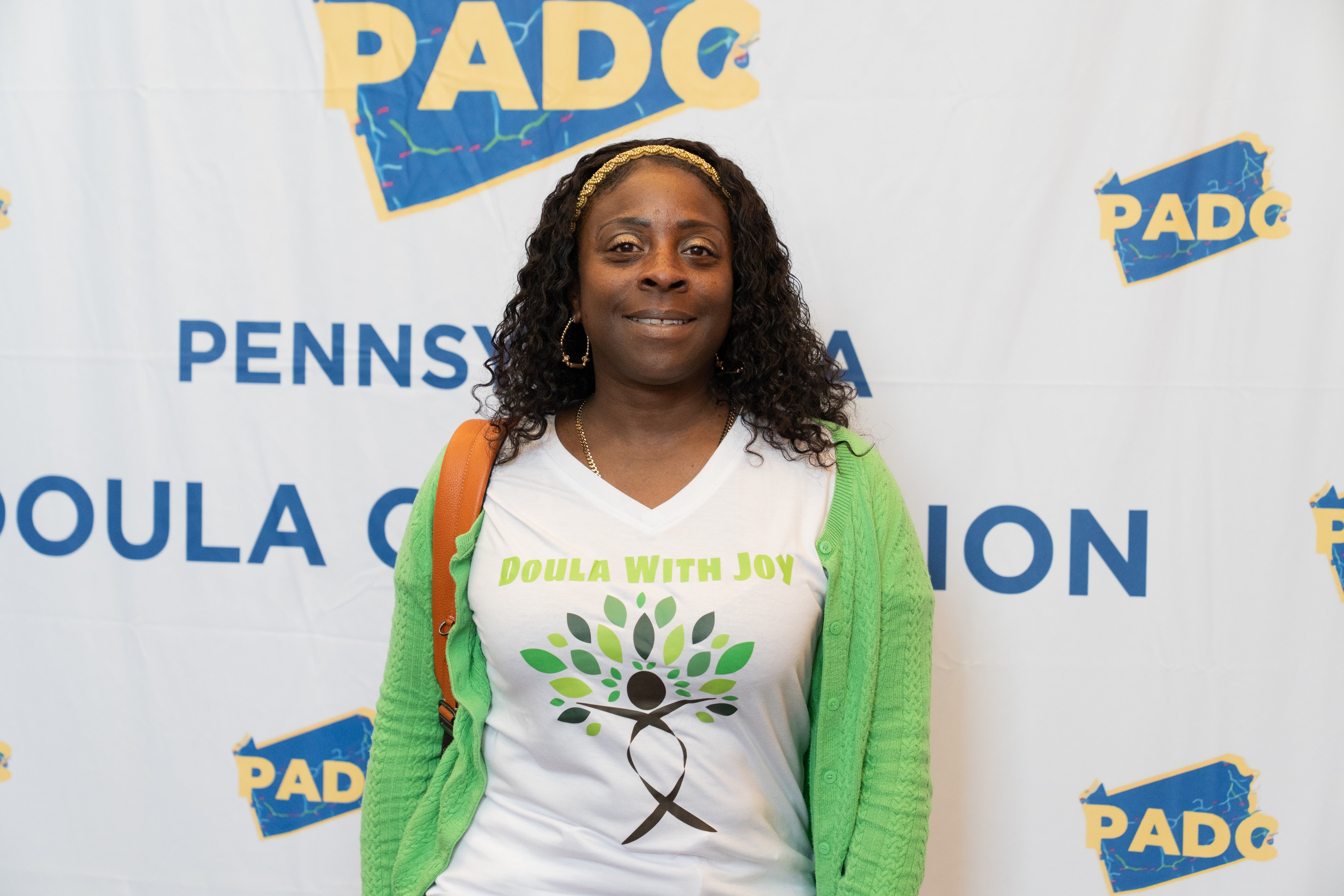 Attendee in front of PADC step-and-repeat banner